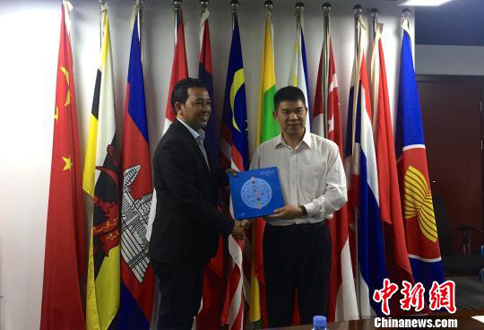 中國(guó)—東盟博覽會(huì)秘書(shū)處副秘書(shū)長(zhǎng)黃平西（右）與柬埔寨新聞部新聞與傳播總司副總司長(zhǎng)春占皮侖（左）互贈(zèng)禮物。